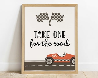 May include: A framed print with a red race car driving on a gray road. The print has the text "TAKE ONE for the road" and two black and white checkered flags.