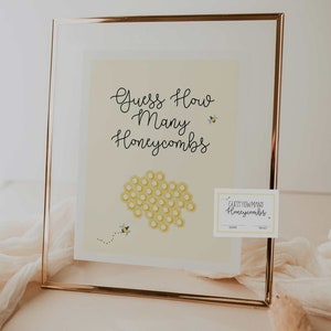 Può includere: Un cartello dorato incorniciato con sfondo giallo e il testo "Guess How Many Honeycombs" con un motivo a nido d'ape e api. Un cartello più piccolo sotto dice "Guess How Many Honeycombs" con righe per un nome e una supposizione.