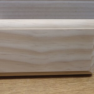 May include: A plain, unfinished, light wood plaque with a slightly rounded edge. The wood grain is visible.