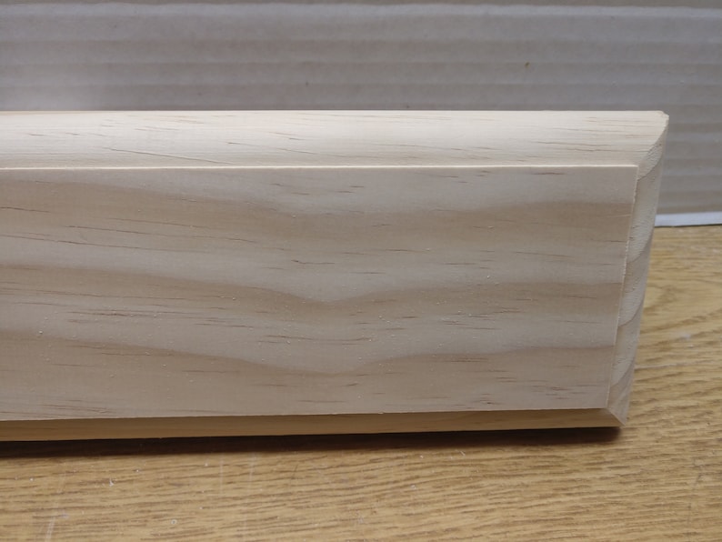 May include: A plain, unfinished, light wood plaque with a slightly rounded edge. The wood grain is visible.