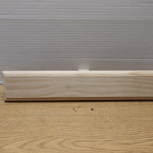 May include: A plain, unfinished wooden plaque with rounded edges. The plaque is made of light-colored wood and has a smooth surface.