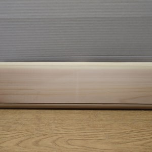 May include: A plain, rectangular wooden plaque with a smooth, light brown surface. The plaque is made of unfinished wood and has a slightly rounded edge.
