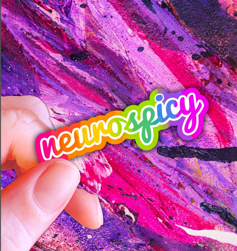 以下が含まれることがあります： ピンク、パープル、ブラックの抽象的な背景に「neuroscipy」というテキストが書かれた虹色のステッカーです。