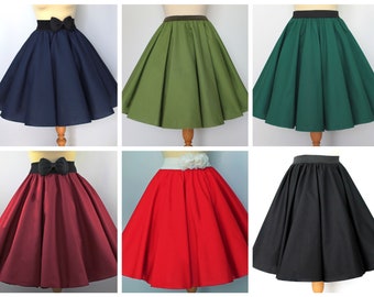 Pode incluir: Uma coleção de seis saias rodadas coloridas. As saias são exibidas em manequins e apresentam uma variedade de cores, incluindo azul marinho, verde oliva, verde floresta, bordô, vermelho e preto. Algumas saias têm laços ou detalhes florais.