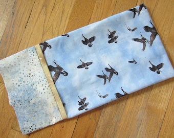 Winged migration! All cotton standard-queen pillowcase with geese on the wing against a clear blue sky.