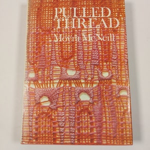 May include: A book titled "Pulled Thread" by Moyra McNeill. The cover features a close-up of a red and orange crocheted fabric.