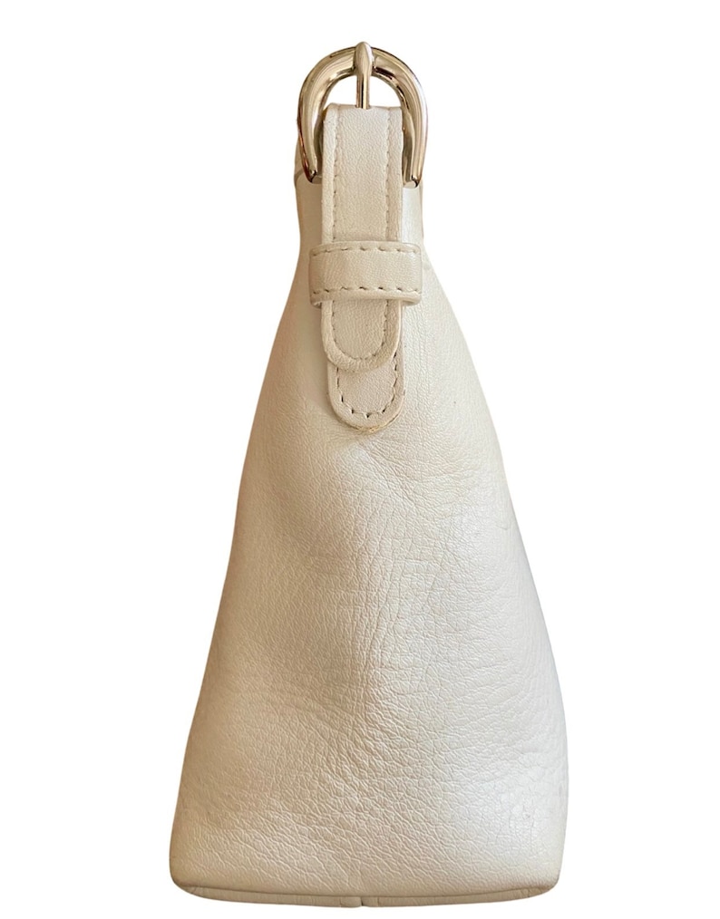 May include: A white leather handbag with a silver buckle closure. The bag has a simple, classic design.