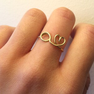 May include: A gold ring with a heart and a circle design.