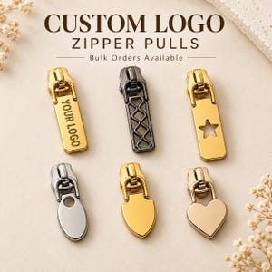 May include: Six metal zipper pulls in various shapes and finishes, including gold, silver, and gunmetal. The top left pull features the text YOUR LOGO, the top middle has a lattice cutout, and the top right has a star cutout. Bottom pulls are oval, shield, and heart-shaped.