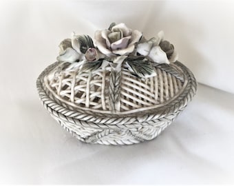 May include: White ceramic trinket box shaped like a woven basket with a lid decorated with three porcelain roses.