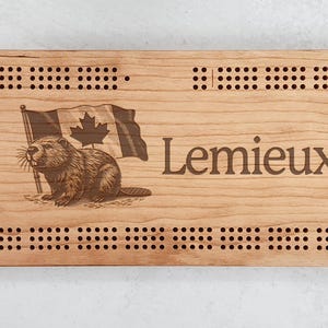 May include: A wooden cribbage board with a beaver and Canadian flag design. The board is personalized with the name "Lemieux".