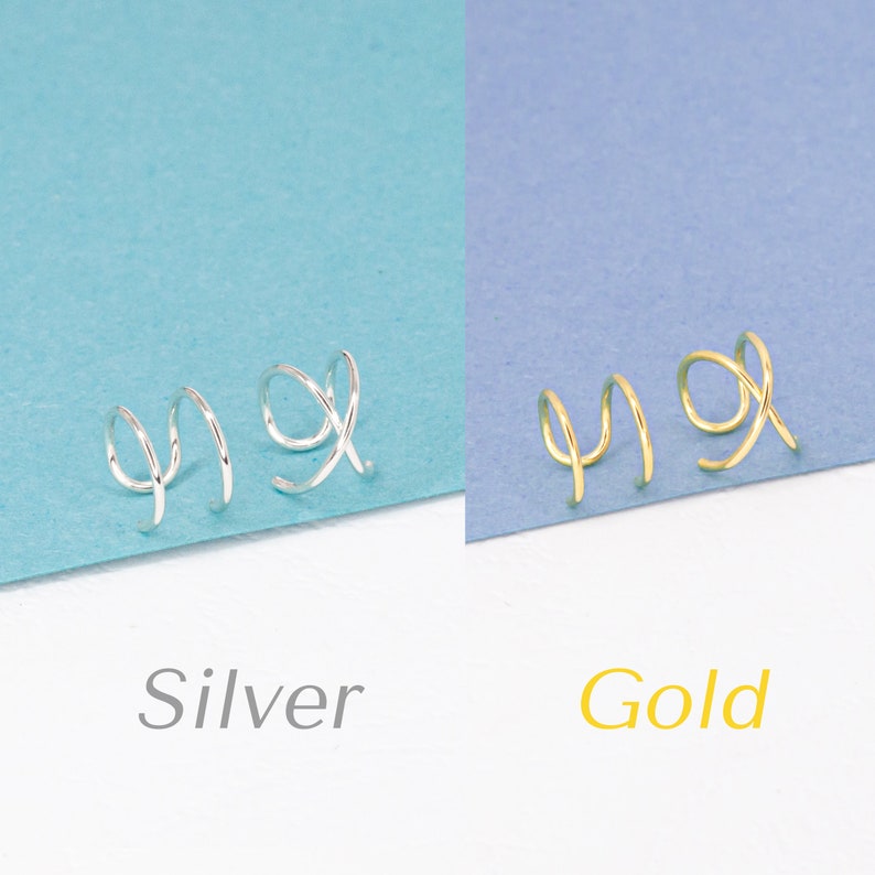 A set of gold earrings featuring two lines and criss cross cuffs, presented on purple paper. In addition, the same set is shown in silver, presented on turquoise color paper.