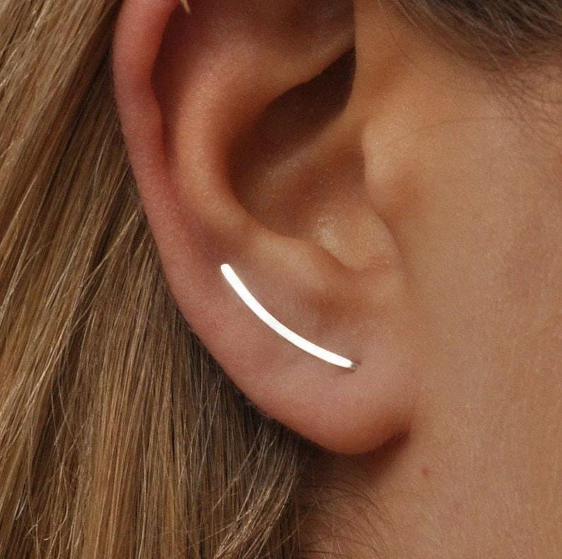 Smooth silver ear climber earring worn on ear, thin curved design for pierced ear