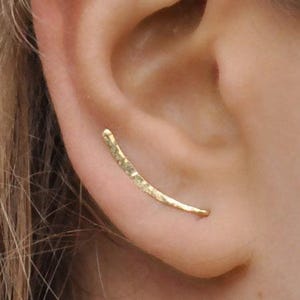 Hammered gold ear climber earring worn on ear, thin curved design for pierced ear