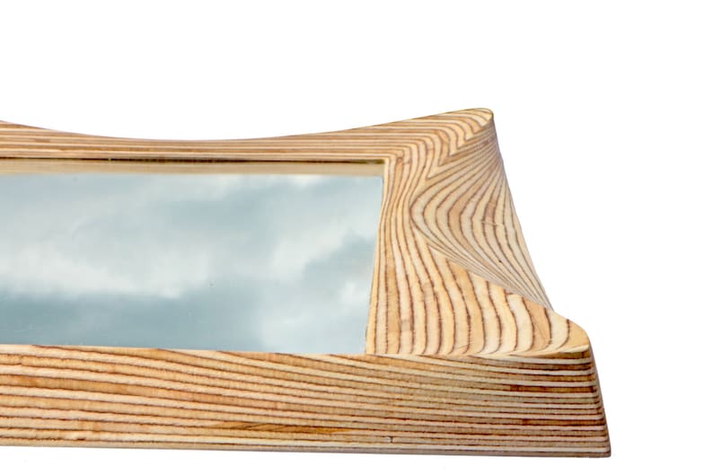 Pode incluir: Uma moldura de madeira para fotos com um design ondulado e org&acirc;nico. A moldura &eacute; feita de madeira clara com um padr&atilde;o de gr&atilde;o natural. A moldura est&aacute; vazia e pronta para conter uma foto.