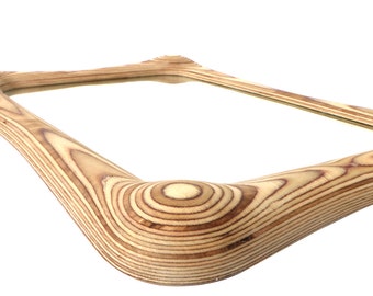 May include: A rectangular mirror with a unique, curved wooden frame made of layered wood veneer. The frame has a natural wood color with a light brown and beige tone.
