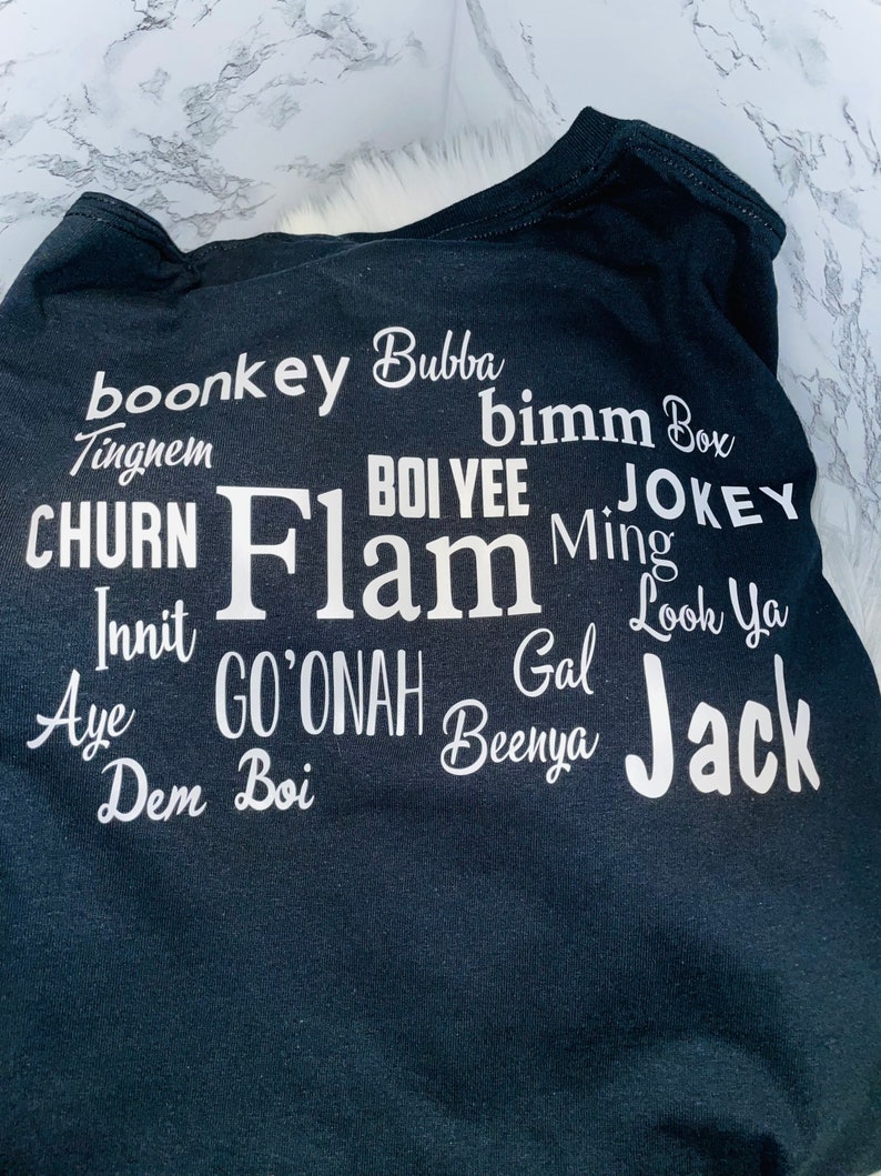 May include: Black t-shirt with white text that reads "boonkey Bubba", "Tingnem", "CHURN", "Innit", "Aye", "Dem Boi", "bimm Box", "BOI YEE", "JOKEY", "Flam", "Ming", "Gal", "GO'ONAH", "Beenya", "Look Ya", and "Jack".