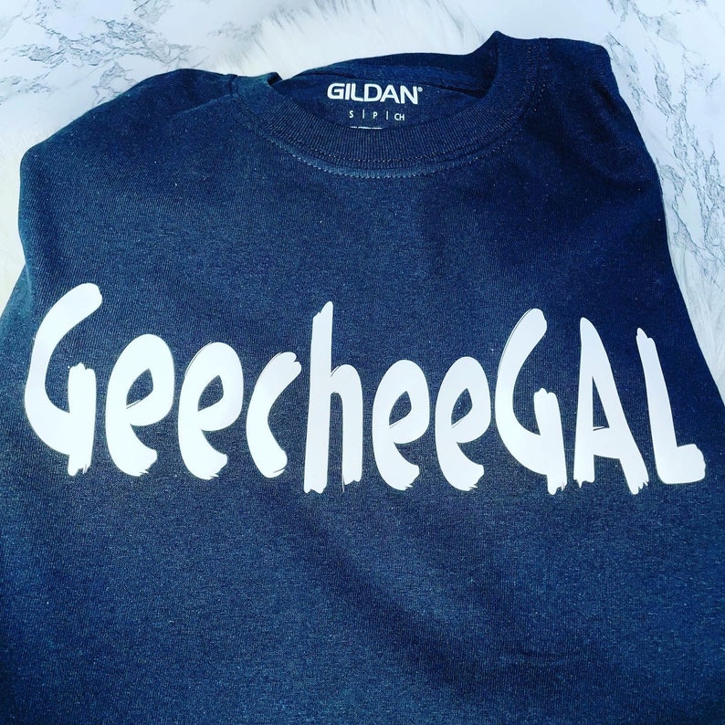 May include: A black Gildan t-shirt with the text "GeecheeGAL" printed in white on the front.