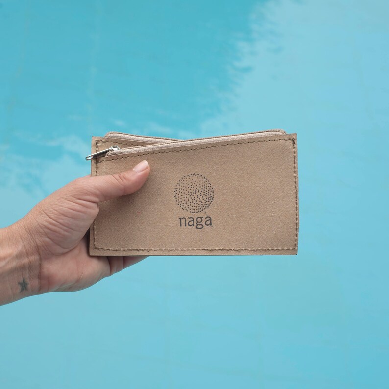 May include: A brown cardboard zippered pouch with a small circle logo that says "naga" in white text.