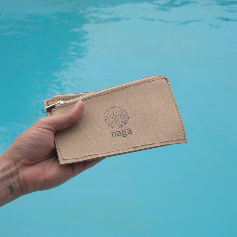 May include: A brown cardboard zippered pouch with a logo that says "naga" and a circle design.