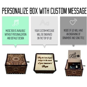 May include: A wooden music box with a floral design on the lid. The lid is open and shows a small metal mechanism inside. The box is engraved with the text "May the best of your today's be the worst of your tomorrow's! Megan".