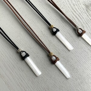 Puede incluir: Cuatro collares de cristal de selenita con cordones de cuero marr&oacute;n y negro. Cada collar tiene un acento de cuentas de plata y oro.