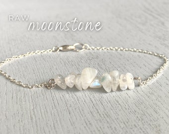 Könnte beinhalten: RAW Moonstone-Armband mit einer silbernen Kette und einer Reihe weißer Moonstone-Chips.