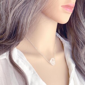 May include: A silver chain necklace with a clear, faceted crystal pendant.