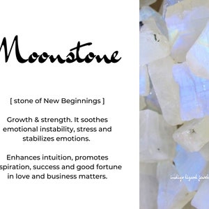 May include: A close-up of a pile of white moonstone crystals. The text "Moonstone" is written in black cursive lettering above the crystals. The text "[stone of New Beginnings]" is written below the crystals. The text "Growth & strength. It soothes emotional instability, stress and stabilizes emotions. Enhances intuition, promotes inspiration, success and good fortune in love and business matters." is written below the crystals. The text "indige lizand jewdry" is written in the bottom right corner of the image.