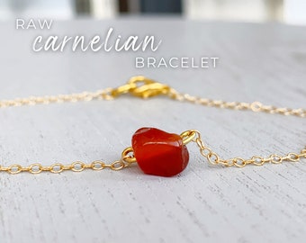 Peut inclure: Un bracelet en chaîne dorée avec une seule pierre de cornaline brute. Le texte "RAW carnelian BRACELET" est affiché au-dessus du bracelet.