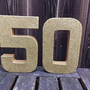 May include: Gold glitter number 50, a popular choice for birthday decorations.