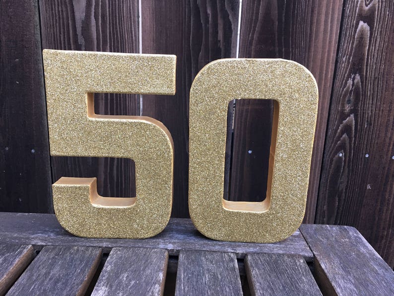 May include: Gold glitter number 50, a popular choice for birthday decorations.