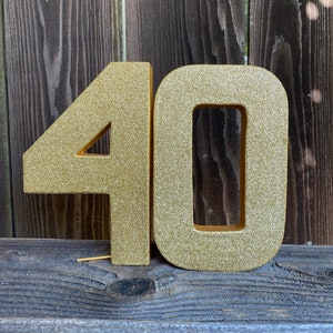 May include: Gold glitter number 40, a popular choice for birthday decorations.