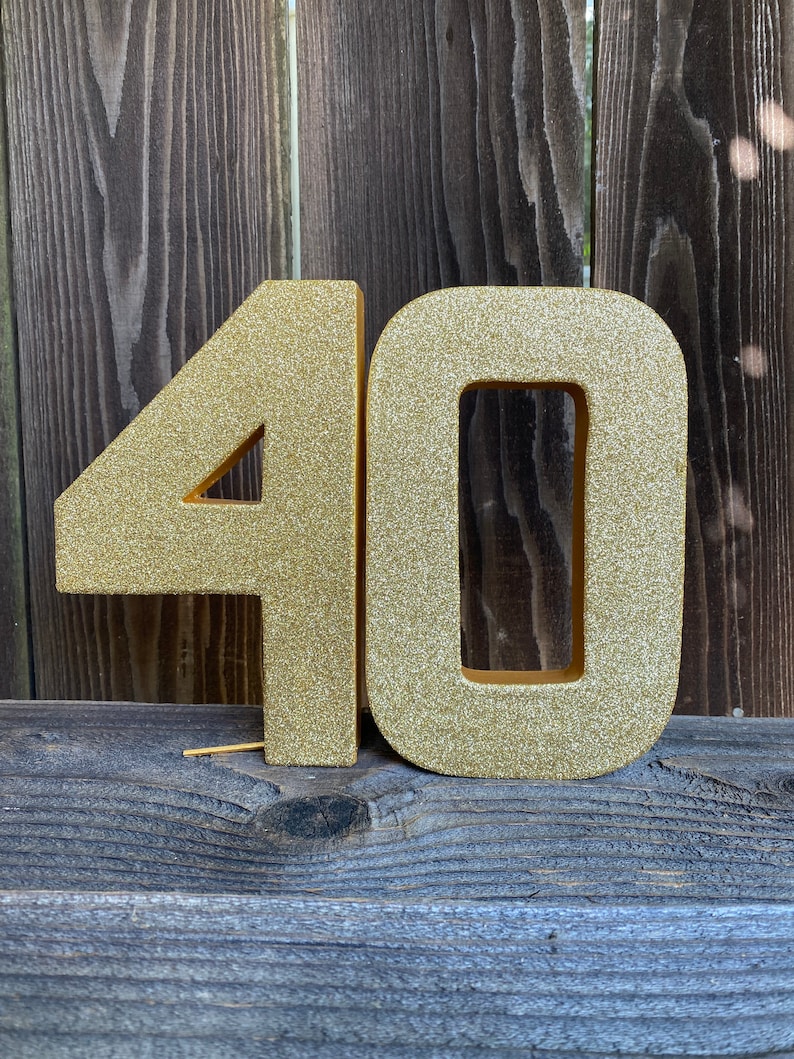 May include: Gold glitter number 40, a popular choice for birthday decorations.