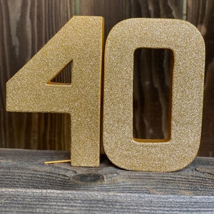 May include: Gold glitter number 40, a popular choice for birthday decorations.