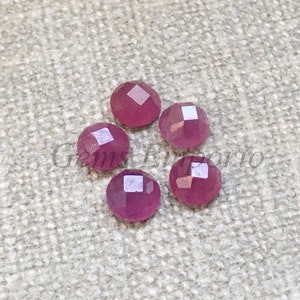 Könnte beinhalten: Sechs rosa facettierte Edelstein-Cabochons, jeder mit einer leicht unterschiedlichen Form und Größe.