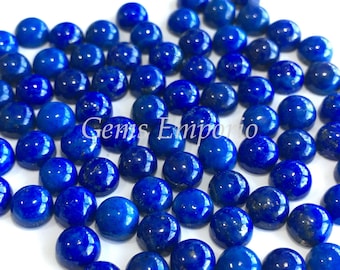 May include: A collection of 50 round, blue lapis lazuli cabochons. The cabochons are smooth and polished, with a deep blue color and some natural inclusions.
