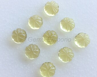 May include: Ten yellow faceted gemstone cabochons with a flower design. The cabochons are round and have a smooth, polished surface.