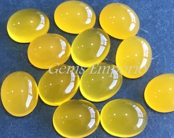 May include: A group of 11 oval-shaped yellow gemstones. The stones are smooth and polished, with a translucent appearance.
