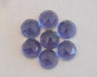 May include: Seven round, faceted, purple gemstones. The gemstones are translucent and have a light purple hue.