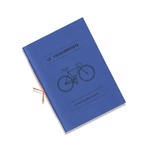 Może przedstawiać: Niebieski notes z ilustracją roweru i tekstem "LE VÉLOCIPÉDISTE Le carnet des belles vadrouilles".