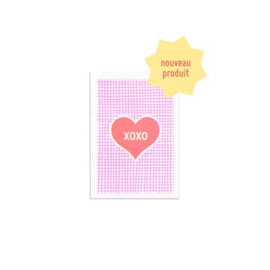 Peut inclure: Une petite carte rectangulaire avec un motif de grille rose et un cœur rouge avec le mot "XOXO" à l'intérieur. Une forme d'éclat d'étoile jaune avec les mots "nouveau produit" est dans le coin supérieur droit.