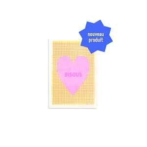 Peut inclure: Une carte rectangulaire avec un cœur rose portant l'inscription "BISOUS". La carte présente un motif quadrillé jaune et une étoile bleue avec l'inscription "nouveau produit".