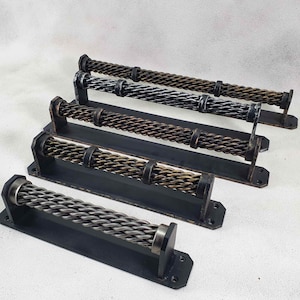 May include: Four different metal door handles with a twisted rope design. The handles are mounted on black metal plates.