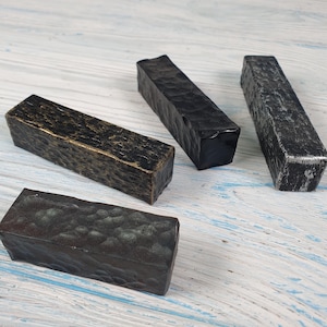 Può includere: Quattro tiretti rettangolari per cassetti in diverse finiture: nero, grigio scuro, grigio chiaro e oro. I tiretti hanno una texture martellata.