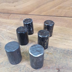 May include: Six black metal drawer pulls with different finishes, including smooth, hammered, and textured.