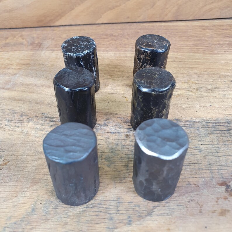 May include: Six black metal cylindrical knobs with a hammered finish. The knobs are arranged in two rows of three.