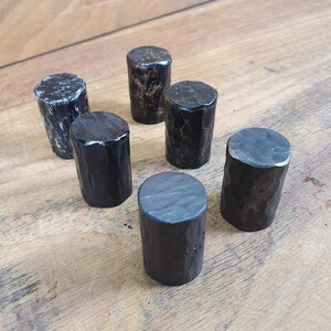 May include: Six black metal knobs with a hammered finish. The knobs are round and have a slightly textured surface.