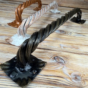 May include: Three metal door handles with a twisted rope design and square mounting plates. The handles are finished in metallic bronze, distressed white, and a dark bronze with gold highlights, each featuring four screw holes for installation.