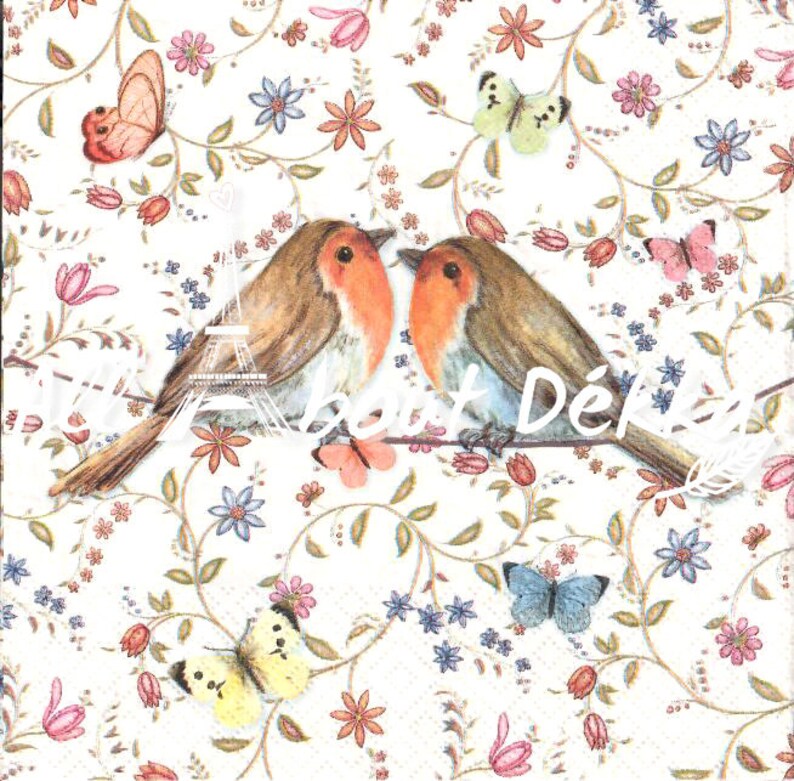 May include: A decorative paper napkin featuring two robins with orange breasts perched on a branch. The background is a floral pattern with butterflies and the text "Petit D&eacute;jeuner". The color palette includes shades of brown, orange, pink, blue, and yellow.